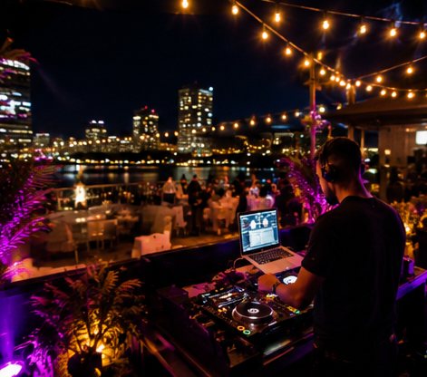 DJ sur un rooftop avec vue sur la ville la nuit